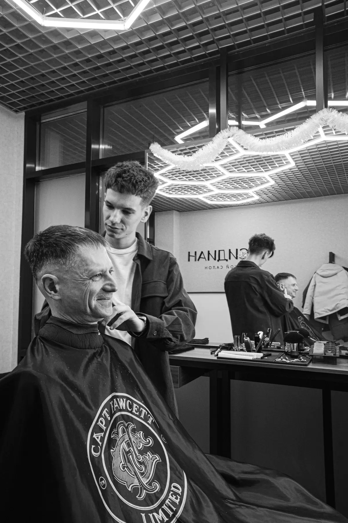 Молодой барбер с клиентом